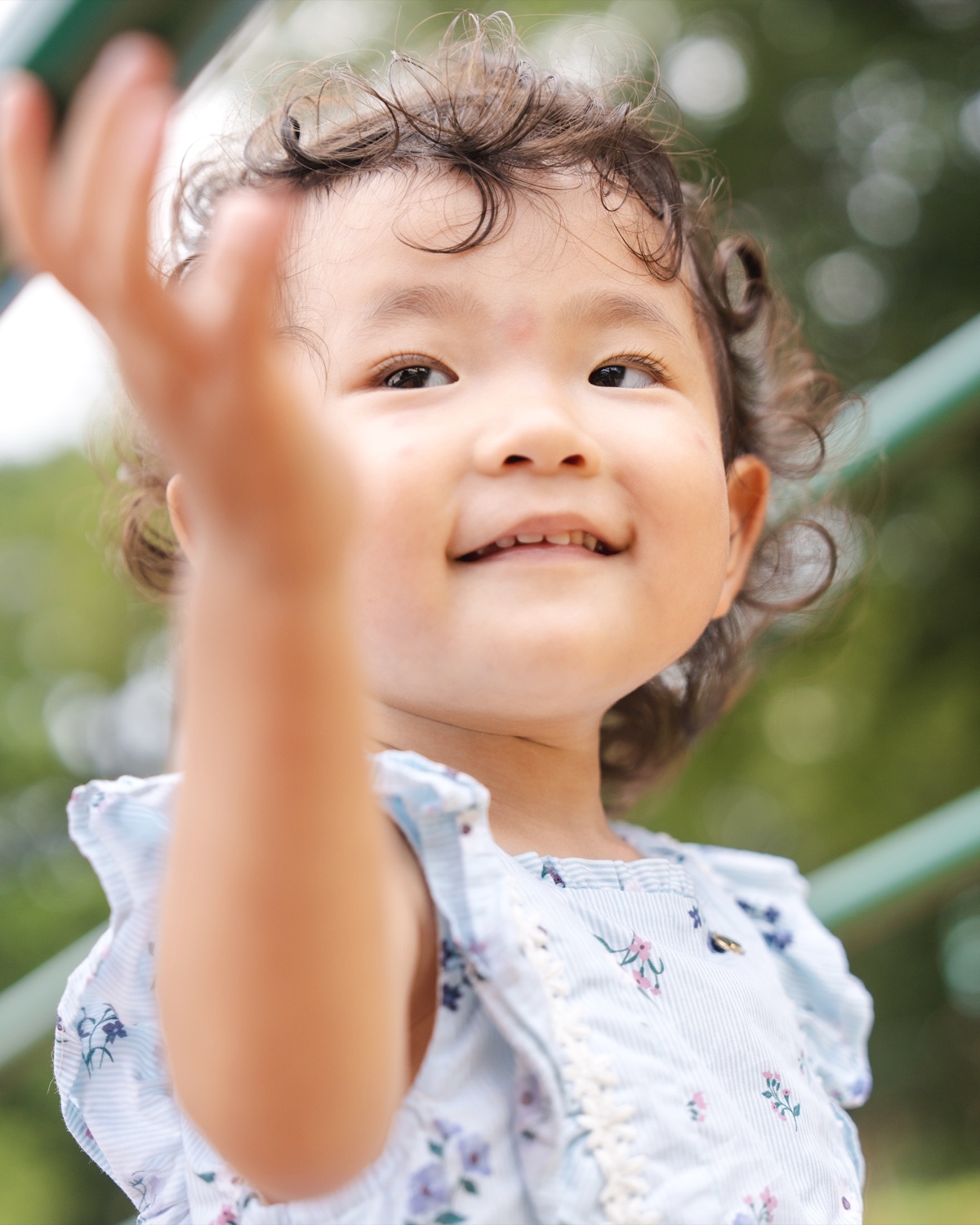 子供が笑顔で手を伸ばす写真