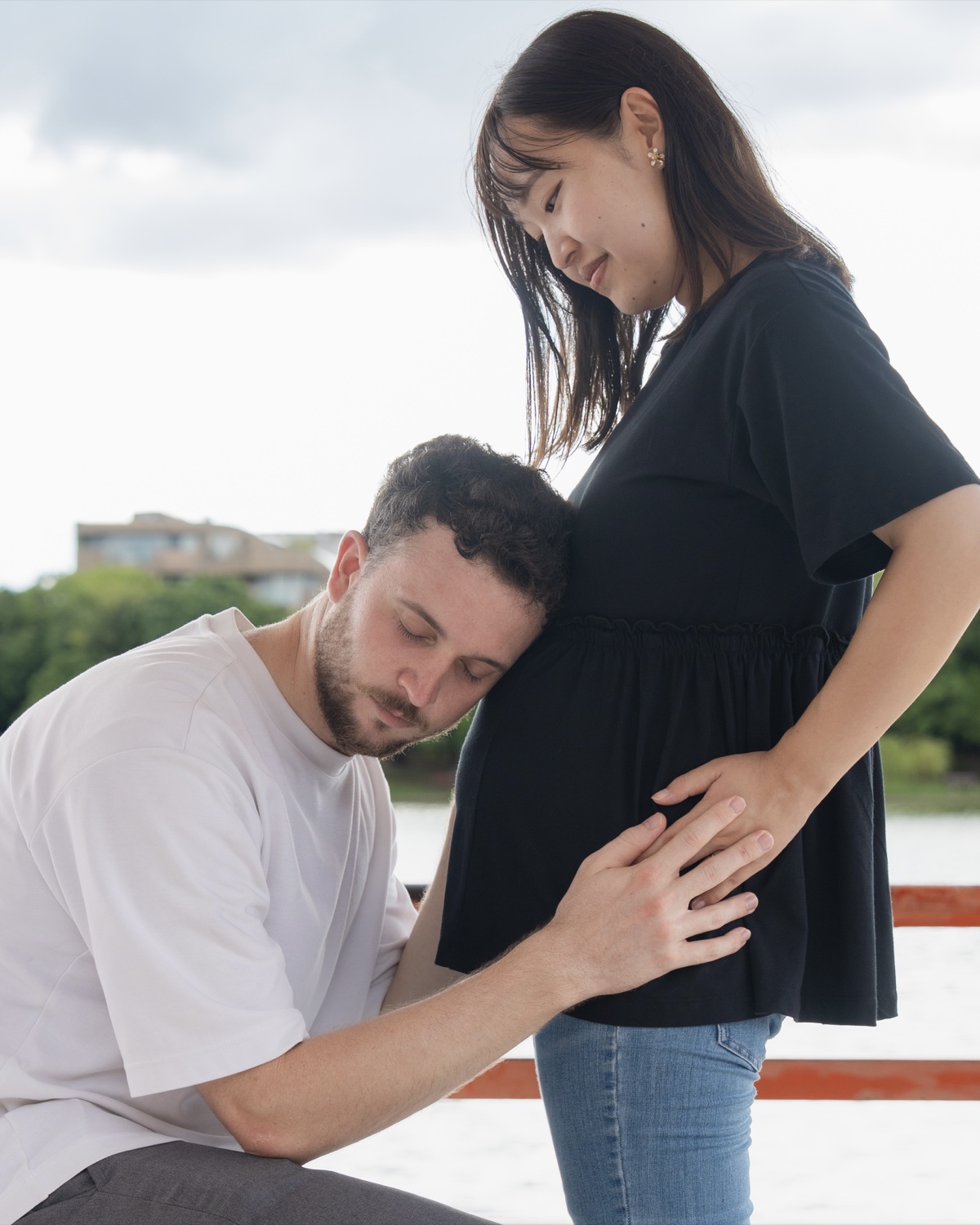 マタニティフォトでお腹に手を添える夫婦の写真