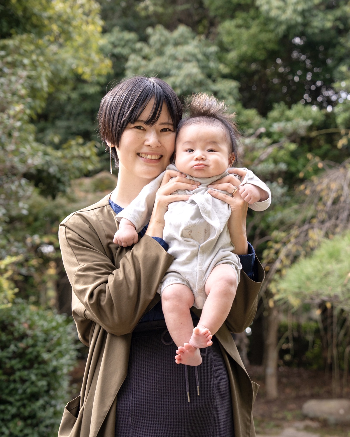 親子で赤ちゃんを抱く写真